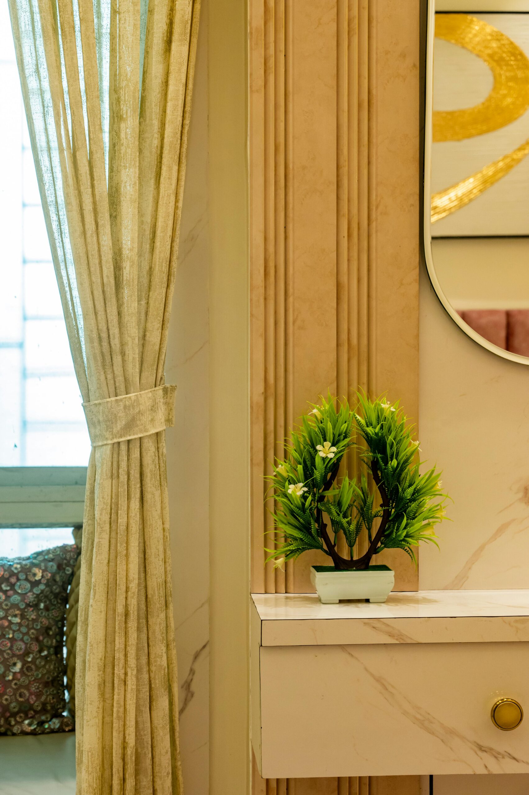 Stylish interior design with marble accents, green plant, and soft drapery, creating a serene atmosphere.